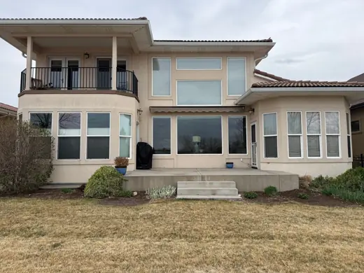 Two-story cream stucco home rear with balcony, Elements Painting project on the Colorado Front Range