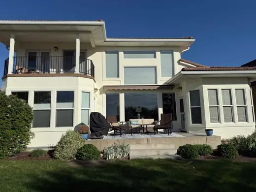 Two-story cream stucco home with balcony and patio, Elements Painting project on the Colorado Front Range