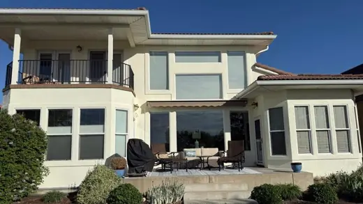 Two-story cream stucco home with balcony and patio, Elements Painting project on the Colorado Front Range