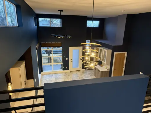 Two-story navy blue great room with stair railing and pendants, Elements Painting project on the Colorado Front Range