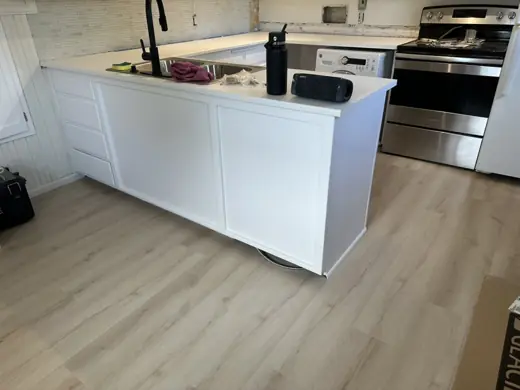 White kitchen island with stainless appliances, light floor, Elements Painting project on the Colorado Front Range