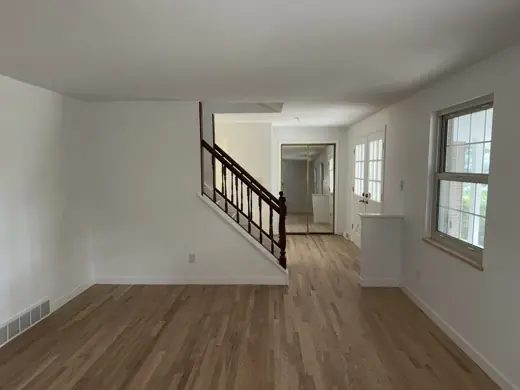 White living room with stair railing, wood floor, Elements Painting project on the Colorado Front Range
