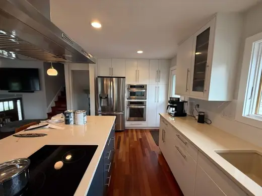 White painted kitchen cabinets, stainless fridge, hardwood floor, Elements Painting project on the Colorado Front Range