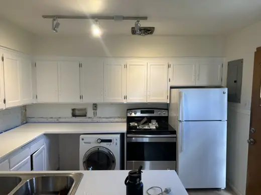 White painted kitchen cabinets, stainless stove, refrigerator, Elements Painting project on the Colorado Front Range