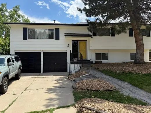 White split-level home, black trim, yellow door, Elements Painting project on the Colorado Front Range