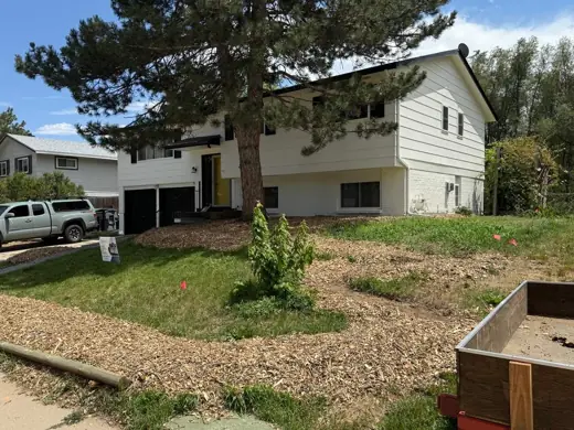 White split-level home with dark trim, yard, Elements Painting project on the Colorado Front Range