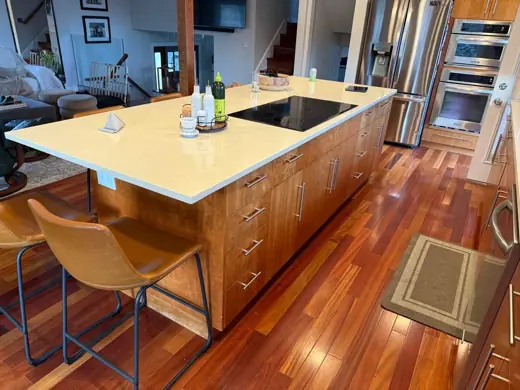 Wood-toned kitchen island with white quartz top, cherry floors, Elements Painting project on the Colorado Front Range