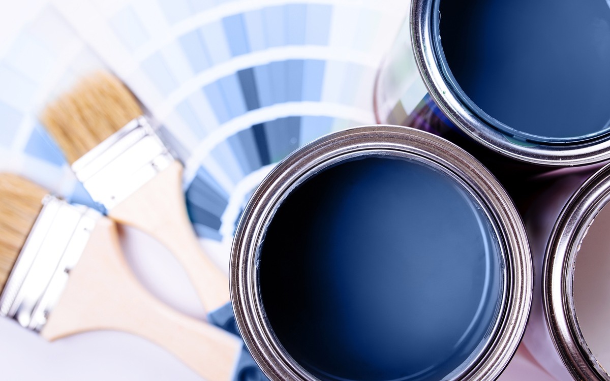 Paint brushes placed on top of can filled with blue paint. Classic blue color of year 2020.