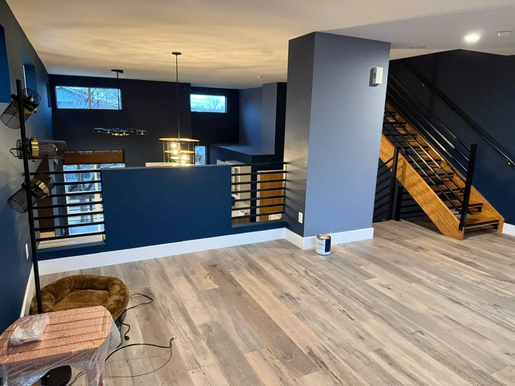 Modern Living Room Interior Painting with Blue Walls Recently painted modern living room featuring dark and light blue walls, light wood flooring, and a multi level design.